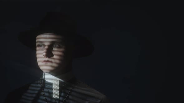 Priest with Blinds Shadow on Face in Dark Studio