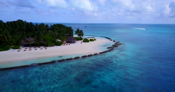 Wide angle flying tourism shot of a white paradise beach and blue sea background in colourful 4K