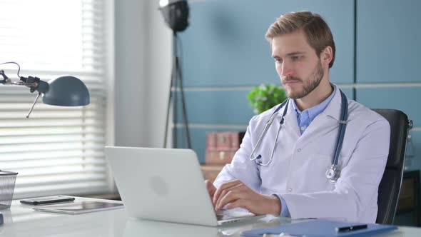 Doctor Working on Laptop in Office