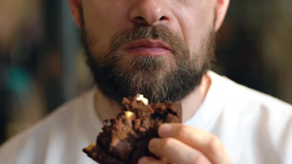 Man Eats a Chocolate Chip Cookies in a Cafe