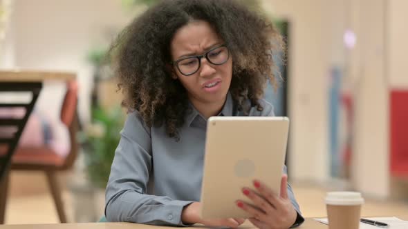 Young African Woman Reacting to Loss on Tablet