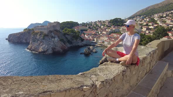 Woman Sitting on Top of Dubrovnik City of Croatia