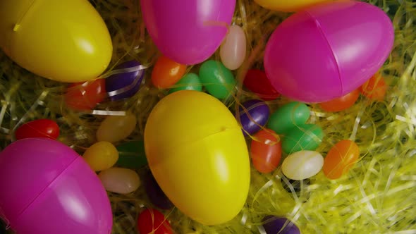 Rotating shot of Easter decorations and candy in colorful Easter grass 