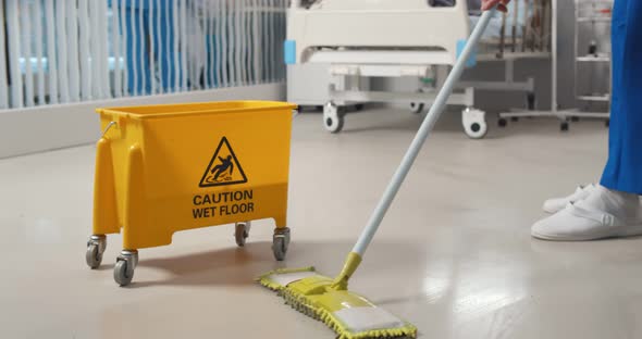 Close Up of Janitor Washing Floor with Mop and Bucket in Hospital Ward