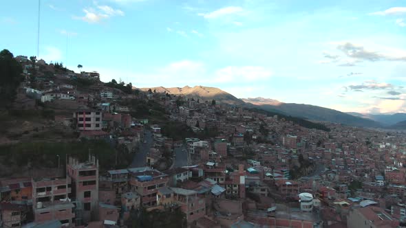 4k daytime aerial drone view over the hill and houses of Alto Los Incas neighbourhood in Cusco, Peru