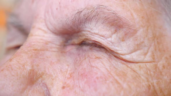 Detail View on Closed Eyes of Old Woman. Close Up of Wrinkled Female Face. Granny Opening Her Eyes