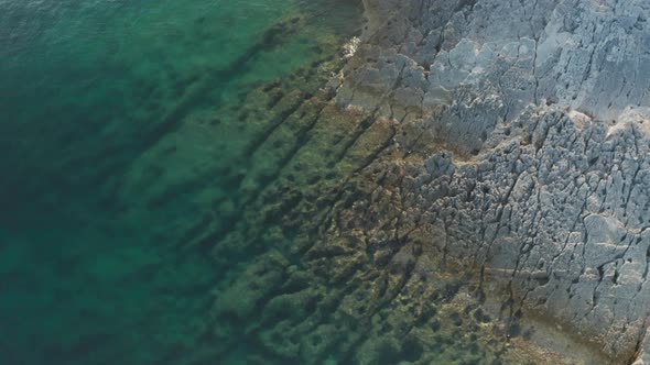 Aerial wide shot of a beautiful coast line on Cape Kamenjak, Croatia. Almost white stoney shore on t