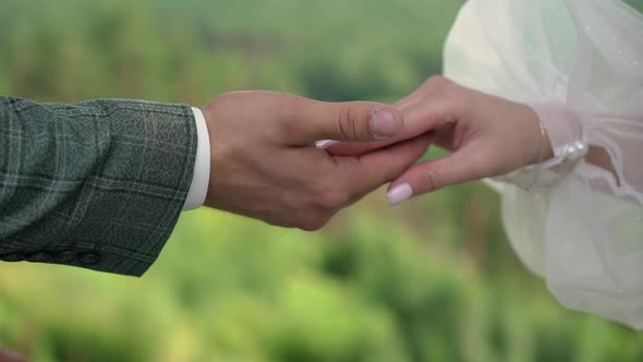 Bride and Groom Stand at Wedding Ceremony Holding Hands