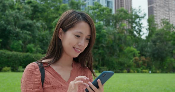 Woman use of the cellphone in city park