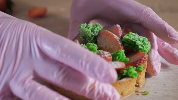 Pastry Chef in Rubber Gloves Shows the Filling of Cutting in Half Strawberry Mini Cake