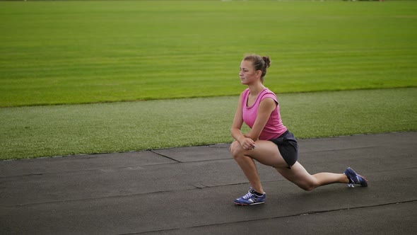 Athletic Girl Doing Lunges Limbering Up at Stadium