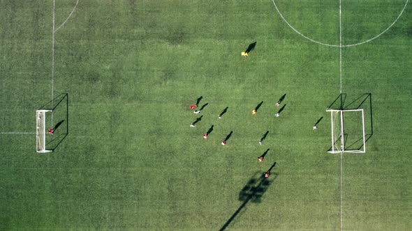 Top View of a Drone Taking Aerial Shots of Kids Playing Soccer on a Soccer Field