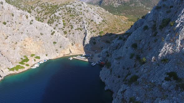 Small Fishing Harbor in a Narrow Valley Between Steep Walled Rocky Mountains