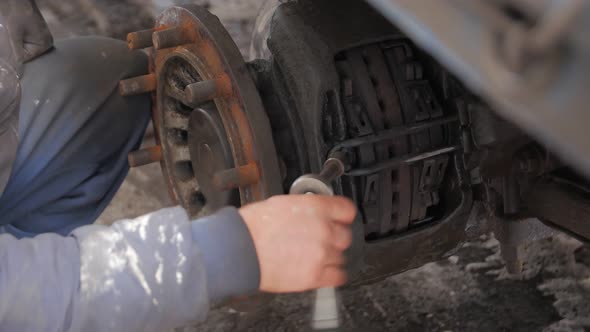 Man Tightening A Bolt In A Car