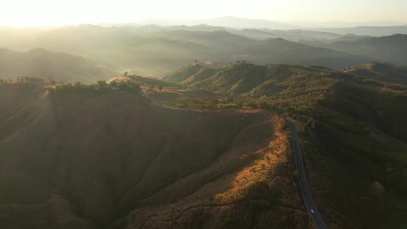 4K Aerial view from drone over mountains fog. Golden scenery at sunrise