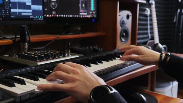 Songwriter Musician Engineer Playing Midi Keyboard Piano in Home Recording Studio with Mixing Gear