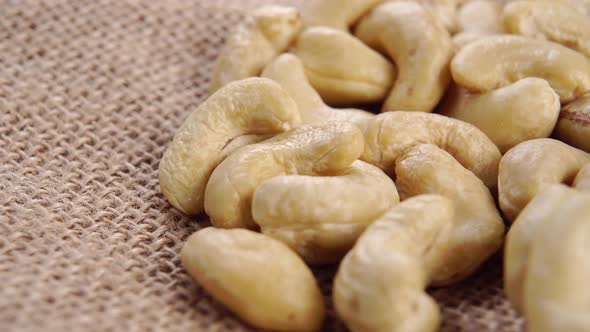 Cashew nut kernels on a rustic rough burlap. Raw organic seeds. Macro