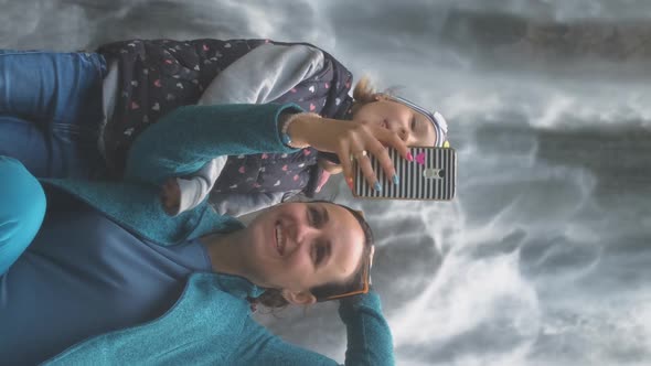 Female with Daughter Taking Selfie By Waterfall