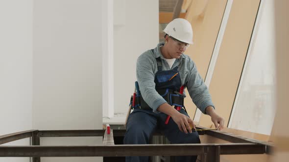 Person Sitting on Metal Structure Measuring