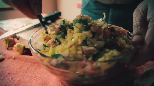 Chef mixing all the vegetables with a spoon in a bowl