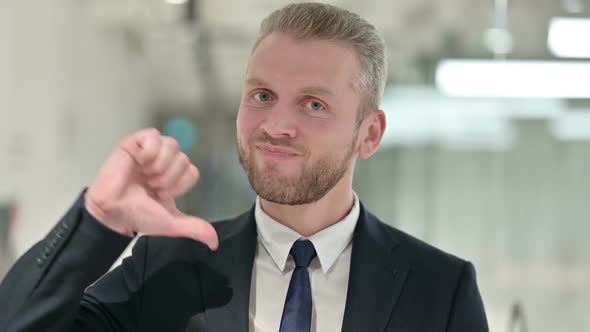 Portrait of Disappointed Young Businessman Doing Thumbs Down