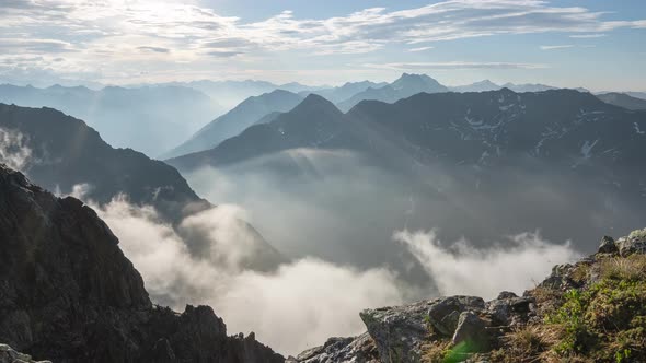 Timelapse on a slider in the mountains with fog in the valley alt