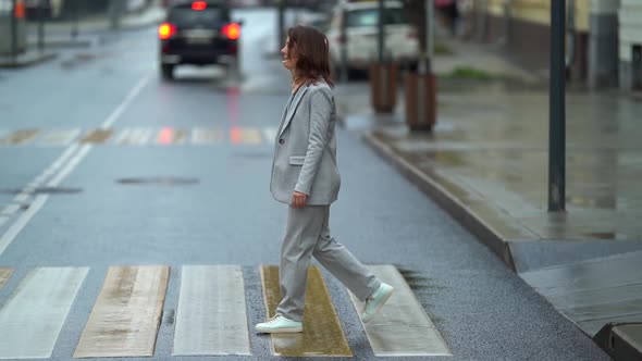 Female Pedestrian Is Walking on Crosswalk in City Street, Lady Is Wearing Cervical Collar