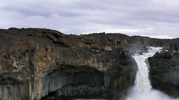 Flying in Slow-motion Around a Tourist at the Aldeyjarfoss Waterfall in Iceland