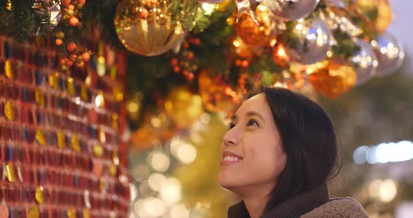 Woman looking at Christmas tree decoration at night