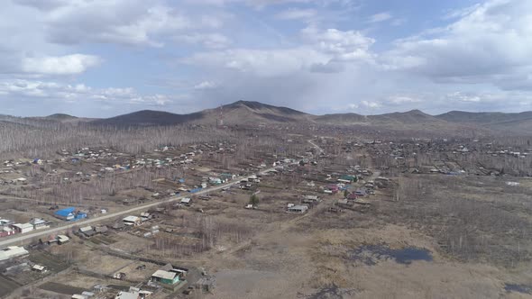 Aerial view of city with private houses. At the background the mountains