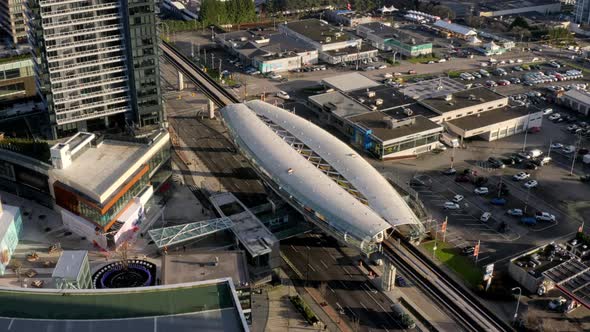 Aerial backward drone shot of Brentwood Town Centre Skytrain Station and its surroundings