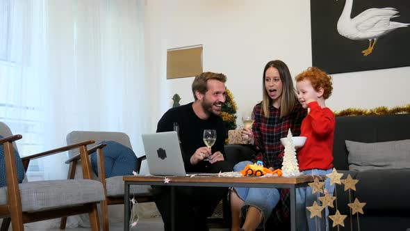 Family using laptop for video call in living room