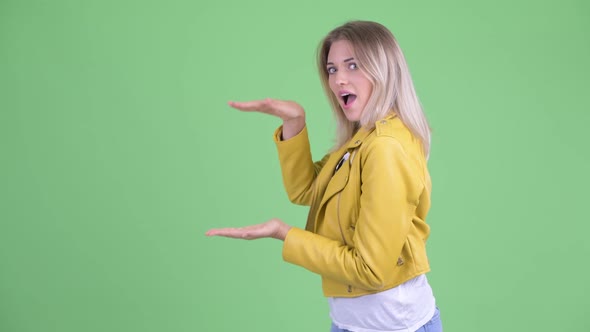 Happy Young Rebellious Blonde Woman Showing Something