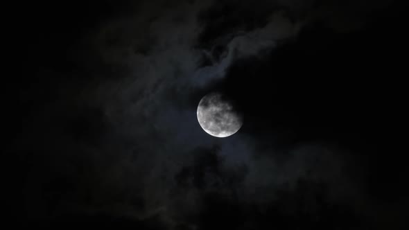 Full Moon Moving Between Clouds