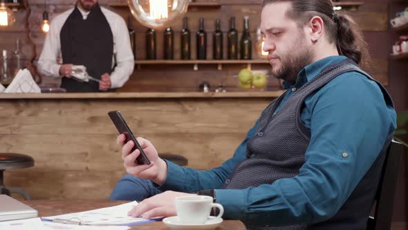 Man Working on His Computer From a Restaurant.