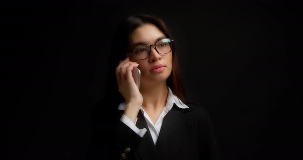 Business Woman Hears Good News on Her Smartphone Shows a Yes Hand Gesture