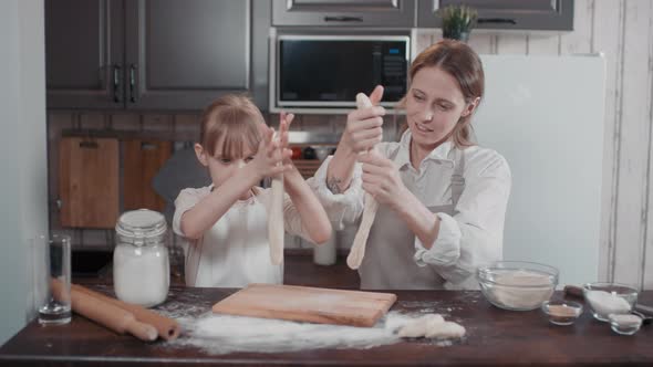 Mom And Daughter Stretching Bread Dough