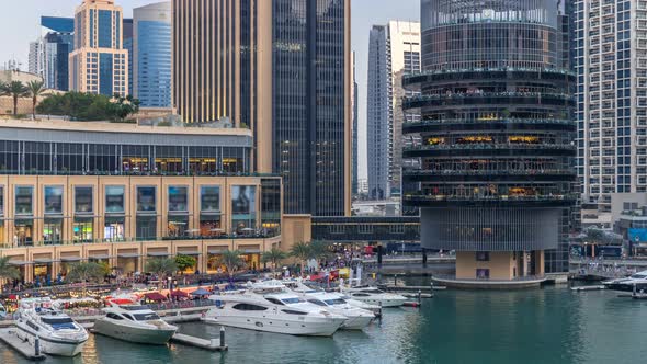 Aerial Vew of Dubai Marina with Shoping Mall Restaurants Towers and Yachts Day to Night Timelapse