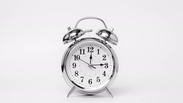 Time lapse of retro alarm clock running isolated on white background.