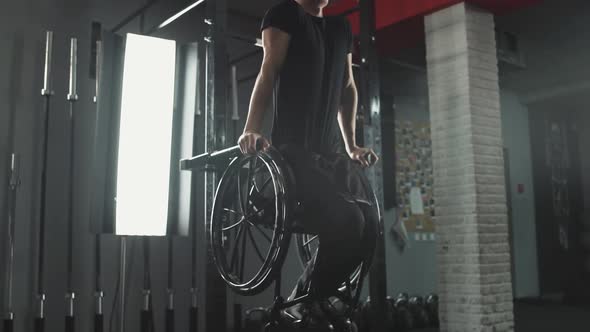 Workout Young Disabled Athlete in Wheelchair Performs Pushups on Bars Gym Training and Physical