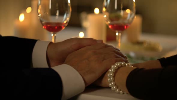 Aged Male Stroking Wife Hands, Married Couple on Romantic Date, Love Expression