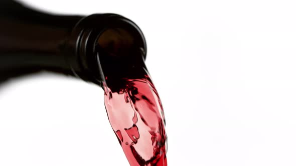 Super Slow Motion Detail Shot of Pouring Red Wine From Bottle Isolated on White at 1000Fps