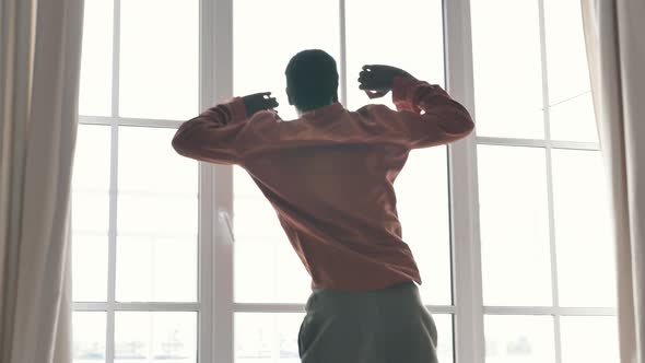 AfricanAmerican Man Stretches Coming to Large French Window