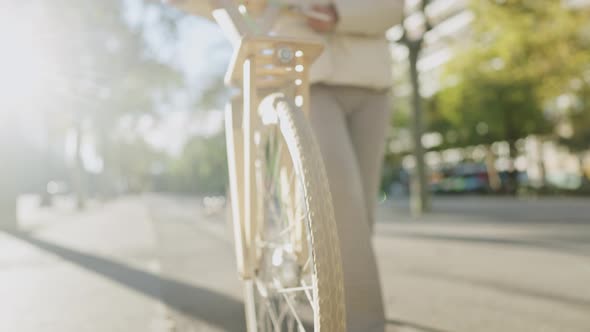 Female Cyclist Walking on Sidewalk