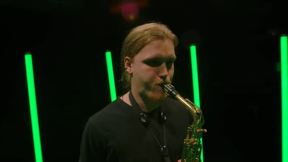 Camera Rotates Around a Young Man Playing the Saxophone