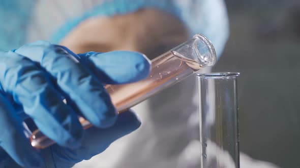 Woman Scientist Working with Liquid in Science Lab. Close Up of Female Scientist Doing Laboratory alt