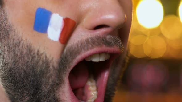 Man Fan With Painted French Flag on Cheek Emotionally Cheering for National Team