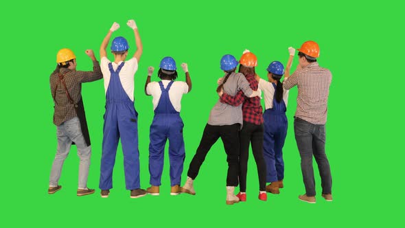 Group of Construction Workers Celebrating Victory with Arms Raised Up on a Green Screen Chroma Key