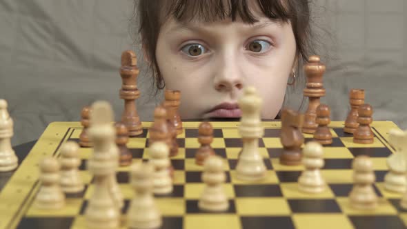 Child think about chess move alone. 