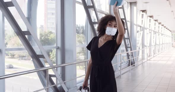 Beautiful African American Girl with Curly Hair in Black Clothes Wears Medical Mask on Her Face